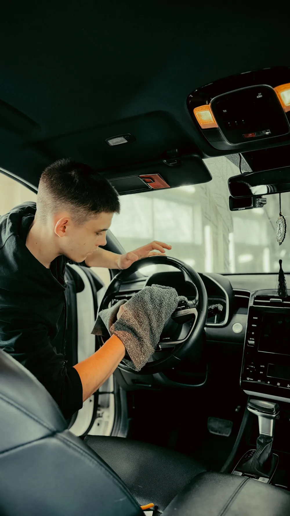 Detailer cleaning a steering wheel